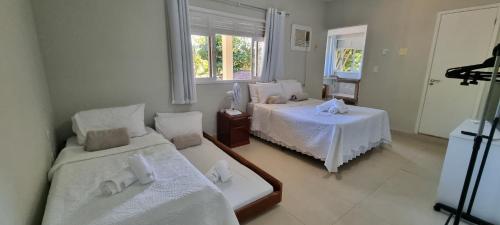 a bedroom with two beds and a window at Maravilhoso Recanto Santa Rosa in Guarapari