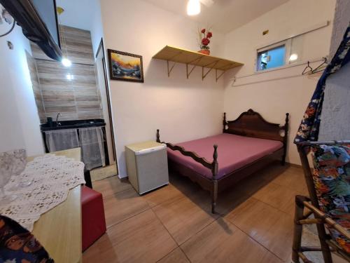 a small bedroom with a pink bed in a room at Chale Sol in Caraguatatuba