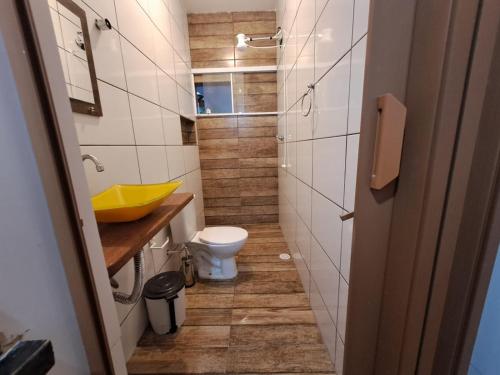 a bathroom with a toilet and a yellow sink at Chale Sol in Caraguatatuba