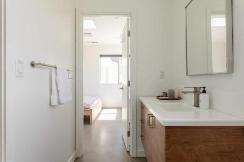 een witte keuken met een wastafel en een spiegel bij Highlands Retreat- Your Own Private Resort w Pool in Joshua Tree