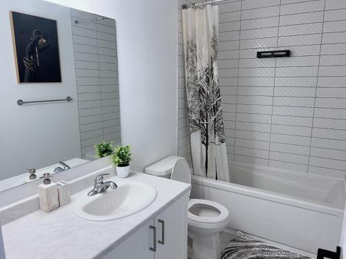 a white bathroom with a sink and a toilet at Voltage in Ottawa