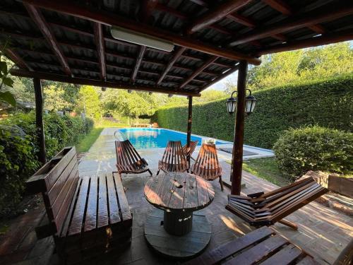 un patio con mesa, sillas y piscina en Cabaña La Huerta "Traslasierra" en Villa Dolores