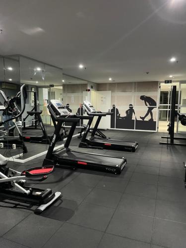 a gym with several treadmills and elliptical machines at Flat particular incrível dentro do hotel QS Oscar Freire, próximo ao Hospital das Clínicas in Sao Paulo