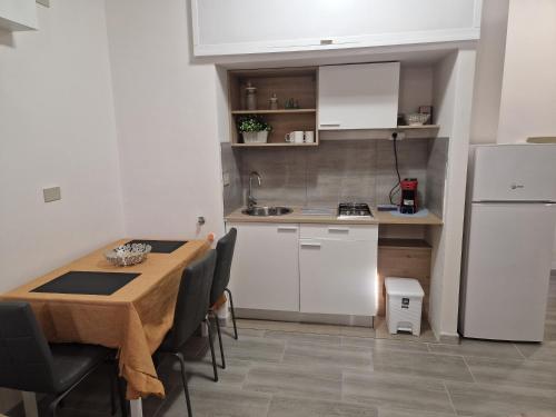 Una pequeña cocina con una mesa y un refrigerador. en Claudio House Palermo, en Palermo