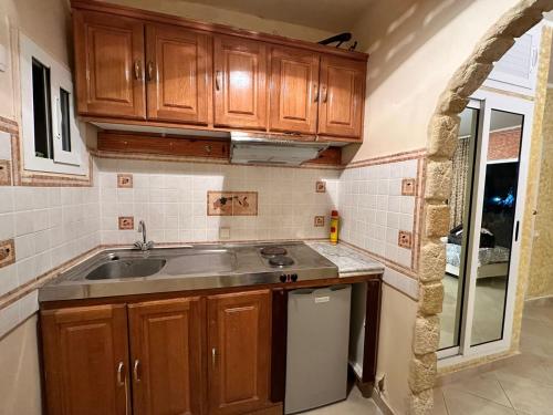 a kitchen with wooden cabinets and a sink at Studio s0 sousse kantaoui maison de la mer in Port El Kantaoui