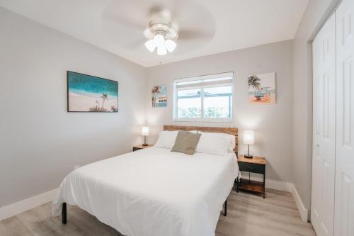 a white bedroom with a bed and a window at Home with heated pool close to beach and FLL airport in Fort Lauderdale