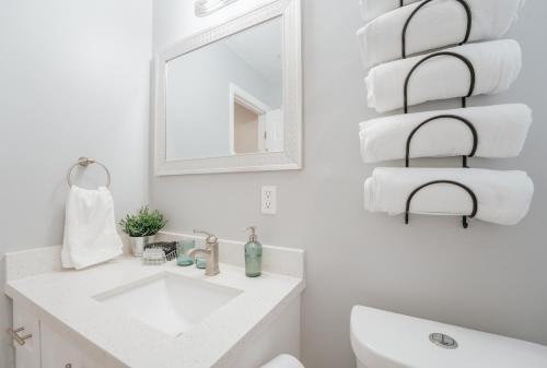 Baño blanco con lavabo y espejo en Home with heated pool close to beach and FLL airport en Fort Lauderdale