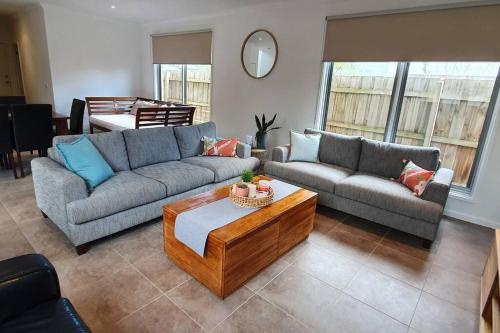 a living room with two couches and a coffee table at Large townhouse direct access to beautiful beach in Safety Beach