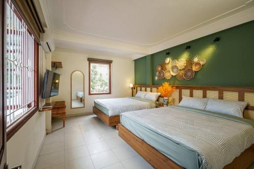 1 Schlafzimmer mit 2 Betten und einer grünen Wand in der Unterkunft Entire 3BR house 3 baths & patio Hoan Kiem Dist in Đà Nẵng