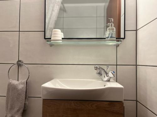 een badkamer met een witte wastafel en een spiegel bij Country Hotel Heydalur in Látur