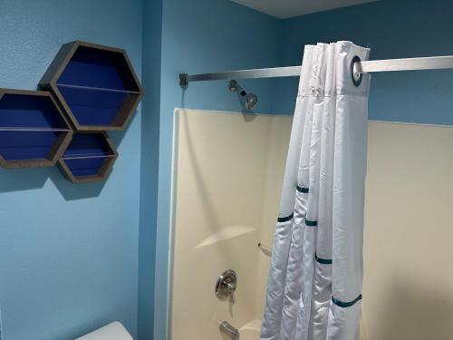 W łazience znajduje się prysznic z białą zasłoną prysznicową. w obiekcie HomeTowne Studios by Red Roof Flint w mieście Flint