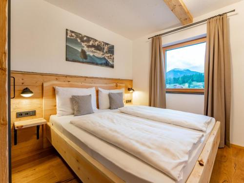 a bedroom with a large bed with a large window at AlmApARTment Mauterndorf Pichl 7-3 in Mauterndorf