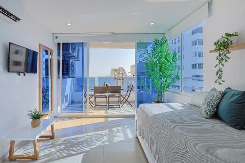 um quarto com uma cama e uma varanda com uma mesa em Riviera Suite - Livin Colombia em Cartagena das Índias