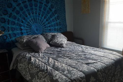 um quarto com uma cama com uma parede azul em Cozy 3 Bedroom House in Downtown Ithaca em Ithaca