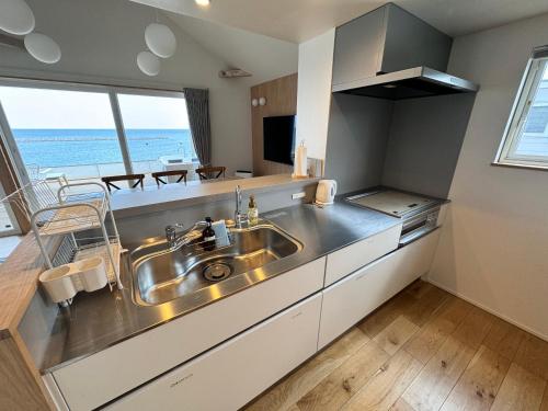 - une cuisine avec évier et vue sur l'océan dans l'établissement Beach SPA TSUDA 0 Cero棟, à Sanuki