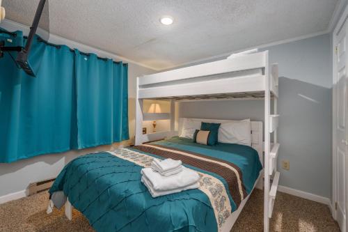1 dormitorio con litera y cortinas azules en Stroll to Slopes, Village Area, Ski in-out MtLodge 219, en Snowshoe