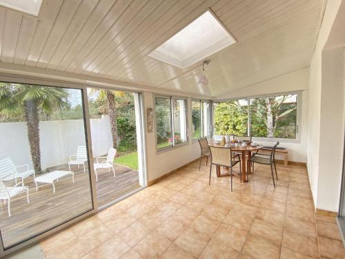 une véranda avec une table et des chaises dans l'établissement Holiday Home in Vendee near Sandy Beaches, à Les Sables-dʼOlonne