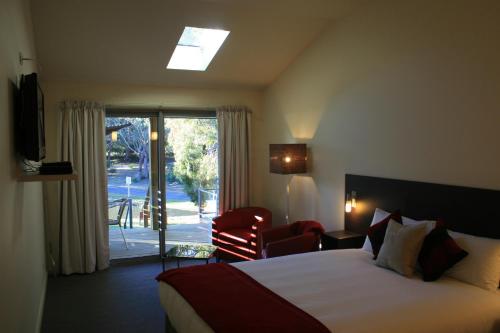 a hotel room with a bed and a sliding glass door at Bicheno by the Bay in Bicheno