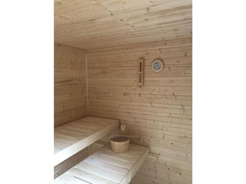 a wooden sauna with a clock on the wall at Lovely apartment in Putbus in Hambühren
