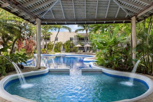 a pool at a resort with waterfalls at Waves Hotel and Spa by Elegant Hotels - All-Inclusive in Saint James