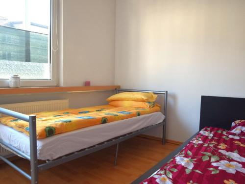 奧伯豪森的住宿－Cosy apartment in Oberhausen with balcony，一间卧室配有一张带黄色枕头的床和一扇窗户