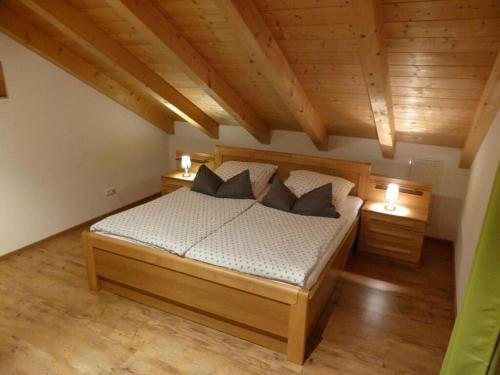 a bedroom with a wooden bed with two night stands at Holiday apartment Burkart in Großweil
