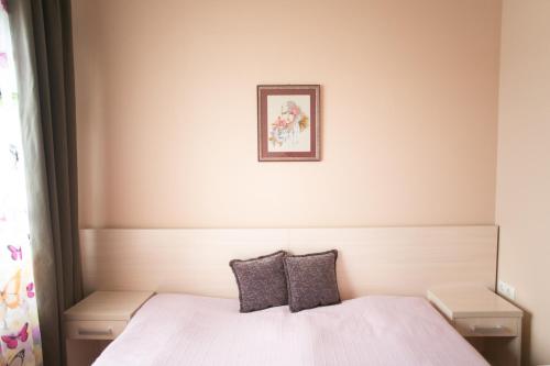 a bedroom with a white bed with two pillows at Tulipan Hotel Aquapark in Vyshkove