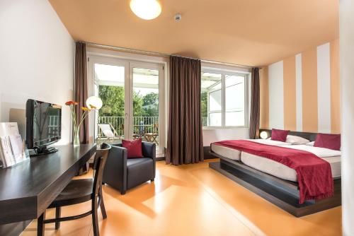 Pokój hotelowy z łóżkiem i biurkiem w obiekcie Hotel Grenzfall w Berlinie