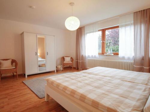 - une chambre avec un lit et une grande fenêtre dans l'établissement Holiday apartment Am Buchbühl, à Stockach