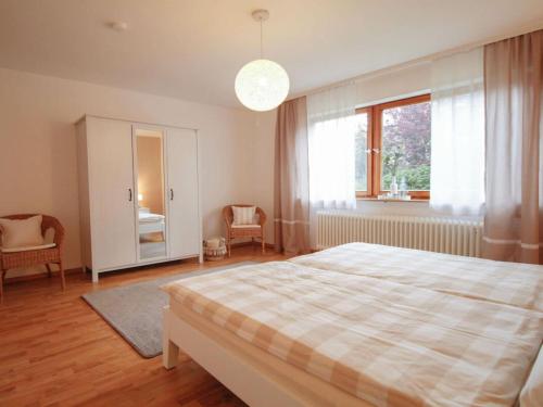 une chambre avec un lit et une grande fenêtre dans l'établissement Holiday apartment Am Buchbühl, à Stockach