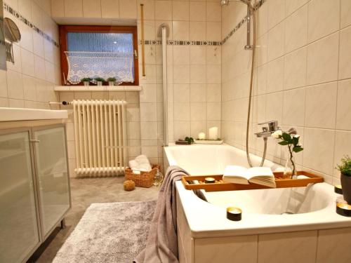 une salle de bain avec une baignoire et un lavabo dans l'établissement Holiday apartment Am Buchbühl, à Stockach