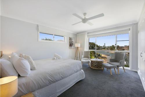 a white bedroom with a bed and a window at Magnificent 4-Bed Waterfront With Pool & Views in Gold Coast