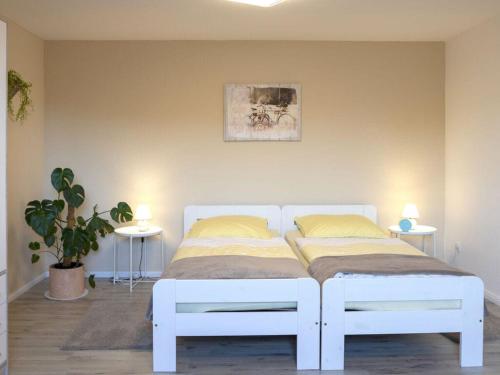 1 cama blanca en una habitación con 2 mesas en Apartment in the Eichengrund, en Häcklingen