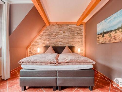 een bed in een kamer met een bakstenen muur bij Holiday maisonette apartment "Keilberg" in Annaberg-Buchholz