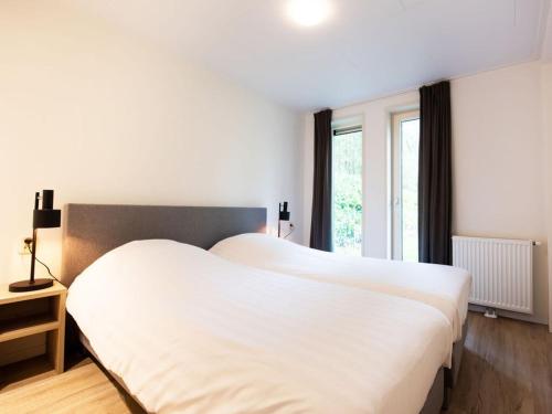 a large white bed in a room with a window at Charming apartment in Graach an der Mosel in Zorgvlied
