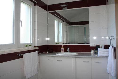 uma casa de banho com um lavatório e um espelho em Apartments with a parking space Razanj, Rogoznica - 22062 em Razanj