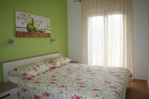 um quarto com uma cama com flores em Apartments with a parking space Razanj, Rogoznica - 22062 em Razanj