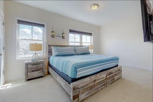 a white bedroom with a bed and a window at Beach House #307 in Hampton