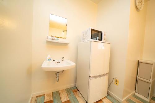 a small bathroom with a sink and a refrigerator at 高原マンション 205 in Matsuyama