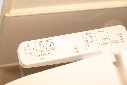 a white remote control on top of a refrigerator at 高原マンション 205 in Matsuyama