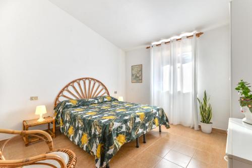 a bedroom with a bed and a chair and a window at Villetta Norsi in Capoliveri