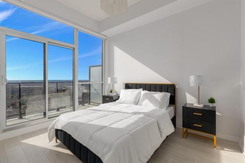 a bedroom with a large bed and large windows at *Luxury 2BR-2BA, High Floor, Unobstructed Lake View* in Toronto