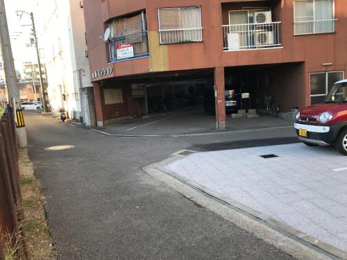 a building with a car parked in front of it at 高原マンション 201 in Matsuyama