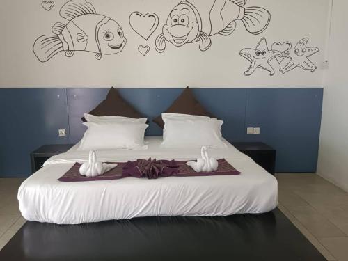 - une chambre avec un lit orné de dessins sur le mur dans l'établissement Pom-Pom Celebes Beach Resort邦邦岛西里伯斯度假村, à Semporna