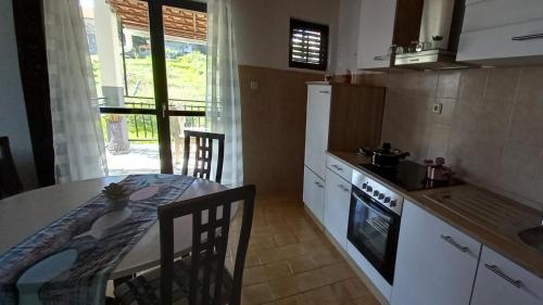 a kitchen with a dining table and a kitchen with a stove at Apartments by the sea Gradac, Makarska - 22388 in Gradac