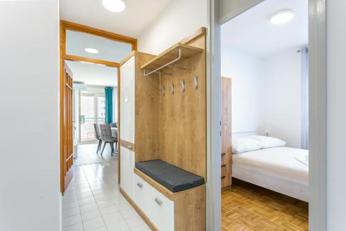 um pequeno quarto com uma cama e um closet em Apartments with a parking space Split - 22452 em Split