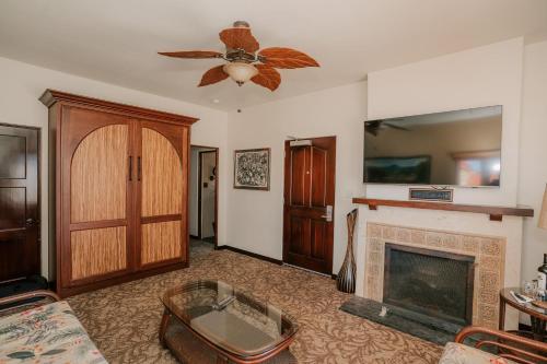 a living room with a fireplace and a ceiling fan at Pantai Inn in San Diego