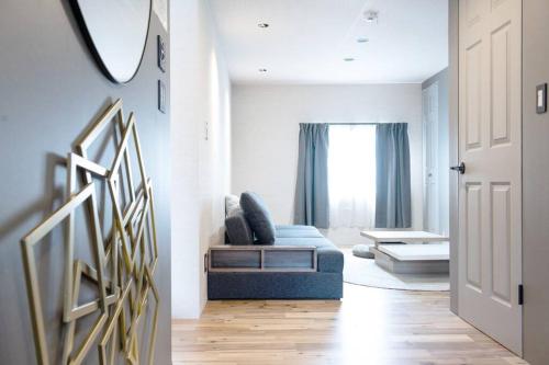 a living room with a blue couch and a window at Sauna Villa Yoichi / 4 bed room with private sauna in Kurokawamachi