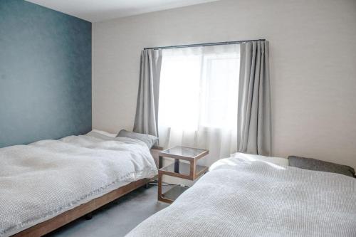 - une chambre avec 2 lits et une fenêtre dans l'établissement Sauna Villa Yoichi / 4 bed room with private sauna, à Kurokawamachi