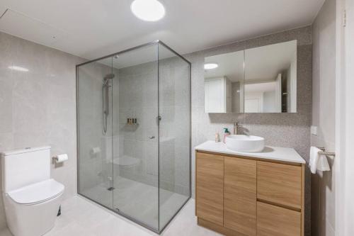a bathroom with a shower and a toilet and a sink at Serain Apartment on Northbourne Ave Canberra in Canberra